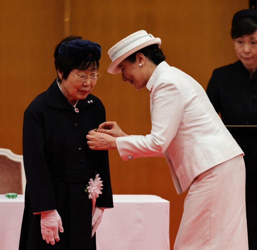フローレンス・ナイチンゲール記章を春山典子さんにつける皇后雅子さま。春山さんは、皇后さまとの懇談のあとに受けたインタビューで、「あの事故から40年。語り続けることが大事なのだといま、ようやくわかりました」と話した=2025年7月31日午後2時22分、東京都港区、JMPA