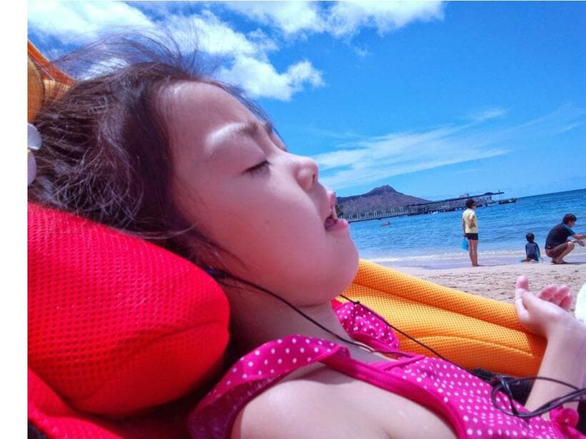 2013年、小学校1年生のゆうちゃん。海辺で「おかあさんといっしょ」の曲を聴きながら海風に当たり、眠くなってきているところ／江利川さん提供