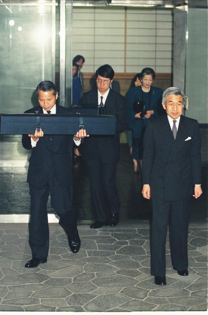 １９９３年　赤坂から新御所へ引っ越す平成の両陛下と紀宮さま。中央奥には、勾玉を運ぶ当時の多賀侍従の姿がある
（C)朝日新聞社