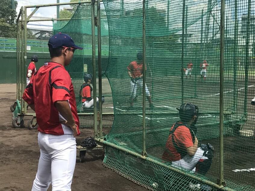 打撃練習を見守る国学院久我山の尾崎監督（左）（撮影／田中将介）