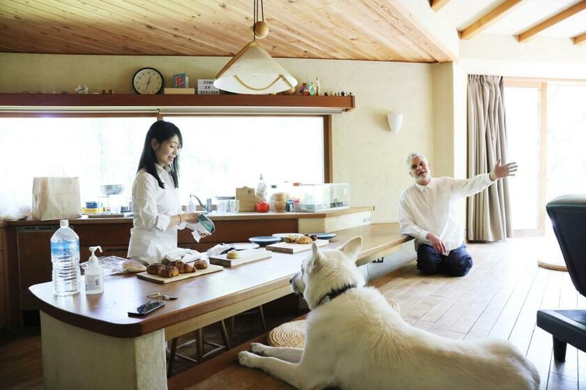 森に囲まれた軽井沢の自宅で、夫のハリスと愛犬アーサーと。ムササビの巣箱は、取り付け時の半分の大きさになった。鈴木は「ムササビがかじったの。ベランダも、こんなに穴があいちゃった」と目を細める（写真＝鈴木愛子）