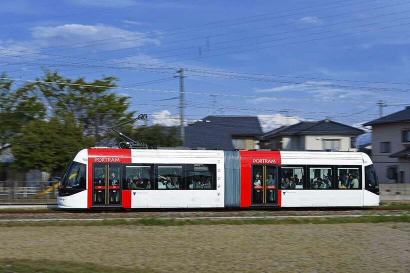 富山ライトレールの開業日は好天に恵まれた。ピカピカのLRVが満員の乗客を乗せて岩瀬浜に向う。フレーミングの中で車体の左端を凝視しながらスムースに体を回転させた。城川原～犬島新町　キヤノンEOS－1Ds MarkIIEF24－70mmF2.8L （70mm） 1／60秒f14 ISO100（撮影／諸河久；2006年4月29日）