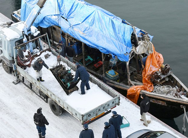 １１月２９日に北海道松前町沖で漂泊しているのが発見された木造船。乗組員１０人のうち３人が１２月９日、窃盗容疑で北海道警に逮捕された。捜査員らが船内から機器を取り出す　（ｃ）朝日新聞社