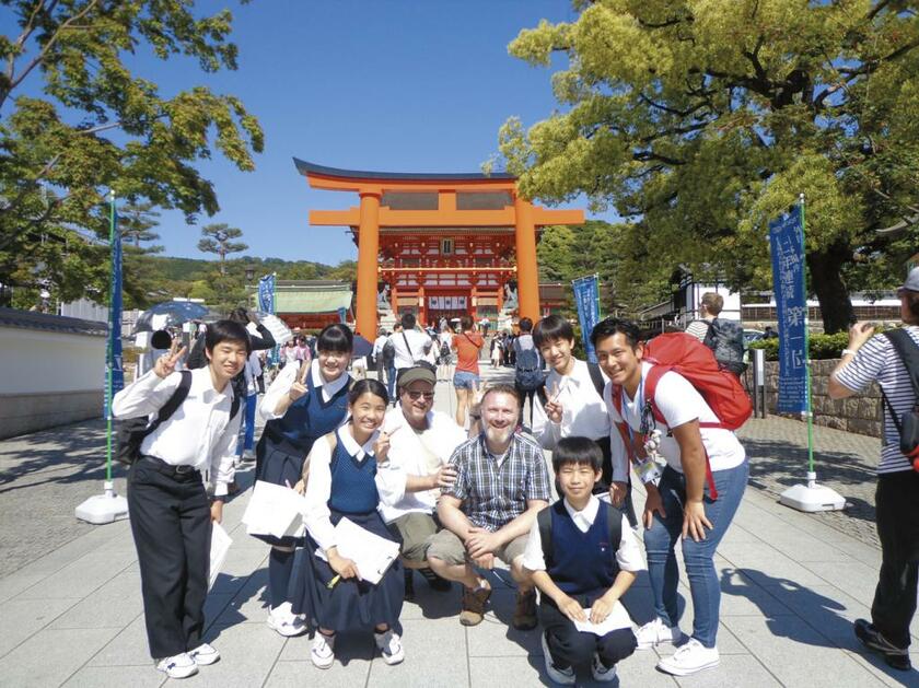 開明／京都市伏見区で直撃インタビューした外国人観光客との記念写真。中3卒業時には４３キロのしまなみ海道を一晩かけて夜間歩行するなど、体験行事を通して生徒のやる気スイッチを押す（写真：開明提供）