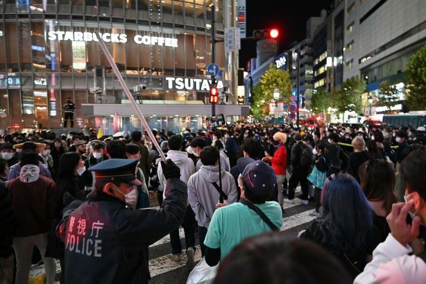 ハロウィーンの夜、ＪＲ渋谷駅前のスクランブル交差点で交通誘導する警察官＝2022年10月31日午後9時