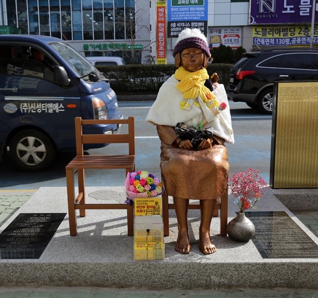 韓国・釜山の日本総領事館前に設置された慰安婦を象徴する「少女像」。作者は「たくさんの人たちと一緒にコミュニケーションできるように」とも考え、少女の姿にしたという。隣のイスに座ることもできる　（ｃ）朝日新聞社