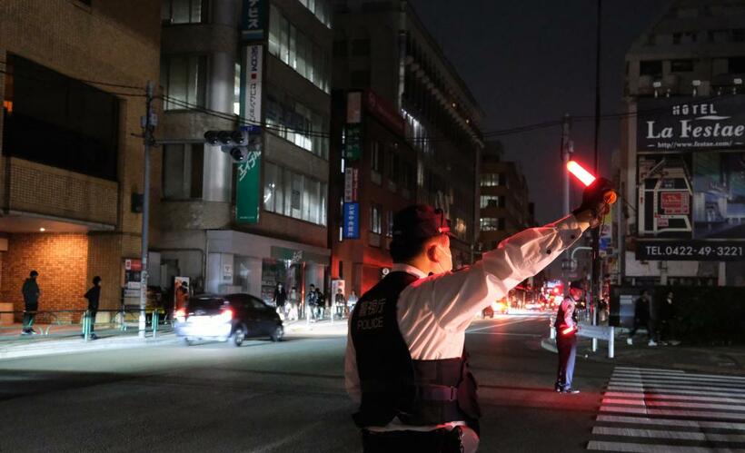 3月17日未明、停電のため手信号で交通整理をする警察官ら／東京都武蔵野市