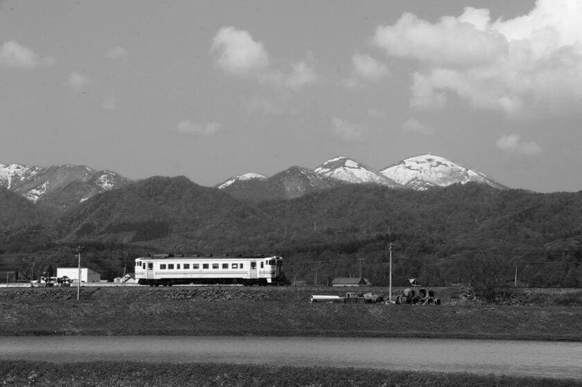 樺戸山塊の最高峰・ピンネシリを見ながら1両編成の列車がゆく（写真提供／坪内政美）