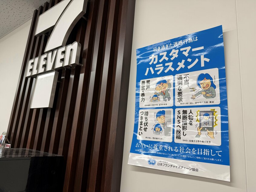 セブン-イレブンのレジカウンター内に貼られたポスター。カスハラにあたる行為がイラストとともに紹介されている=2024年12月13日、東京都千代田区
