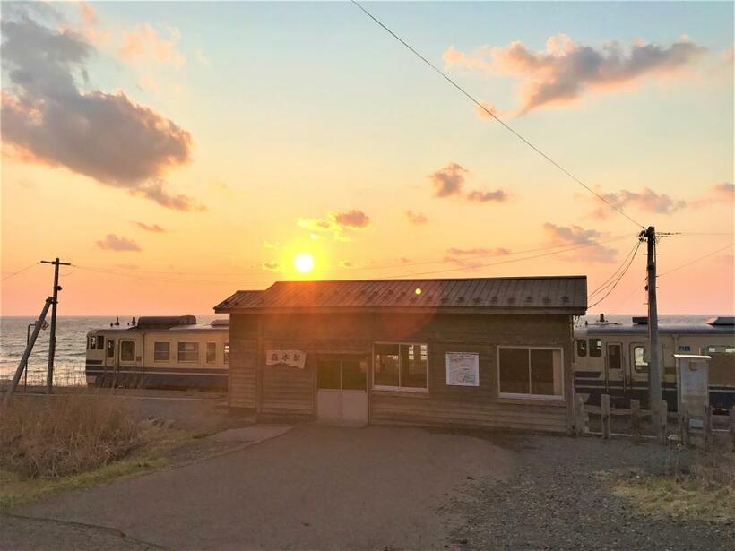 【五能線】
能代－深浦（ＪＲ東日本）
海岸線は岩礁地帯で変化に富んでいる。沿線は夕焼けが美しい。写真は、驫木（とどろき）駅と沈む夕日、そして普通列車（ｐｈｏｔｏ　青森県深浦町役場提供）