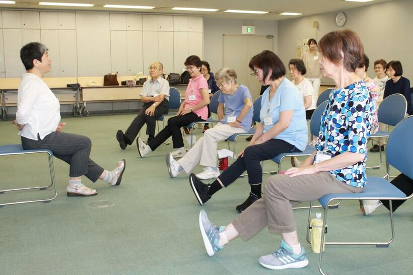 東京都文京区での「転倒骨折予防教室」（村田くみ撮影）。参加者は、右膝を伸ばしてつま先をおなか側に引くエクササイズ「片膝伸ばし」に取り組んでいた