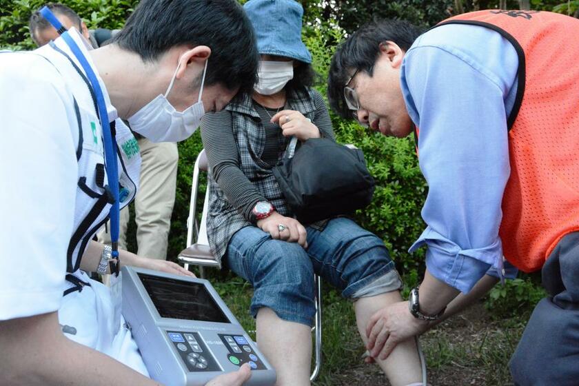 榛沢医師（写真右）は被災地での診察もしている。熊本地震の際には、避難者の女性の足から血栓を見つけた／２０１６年４月、熊本県益城町　（ｃ）朝日新聞社