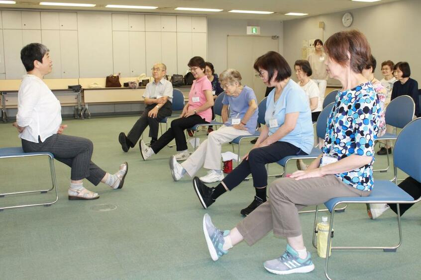 東京都文京区での「転倒骨折予防教室」(村田くみ撮影)。参加者は、右膝を伸ばしてつま先をおなか側に引くエクササイズ「片膝伸ばし」に取り組んでいた