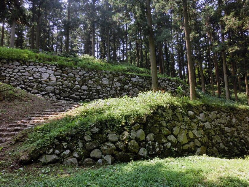 七尾城（石川県）の桜馬場。軍馬を調練した場所とされ、曲輪東北側には石垣が五段に積まれていた。城下から高石垣に見える効果を狙ったらしい。