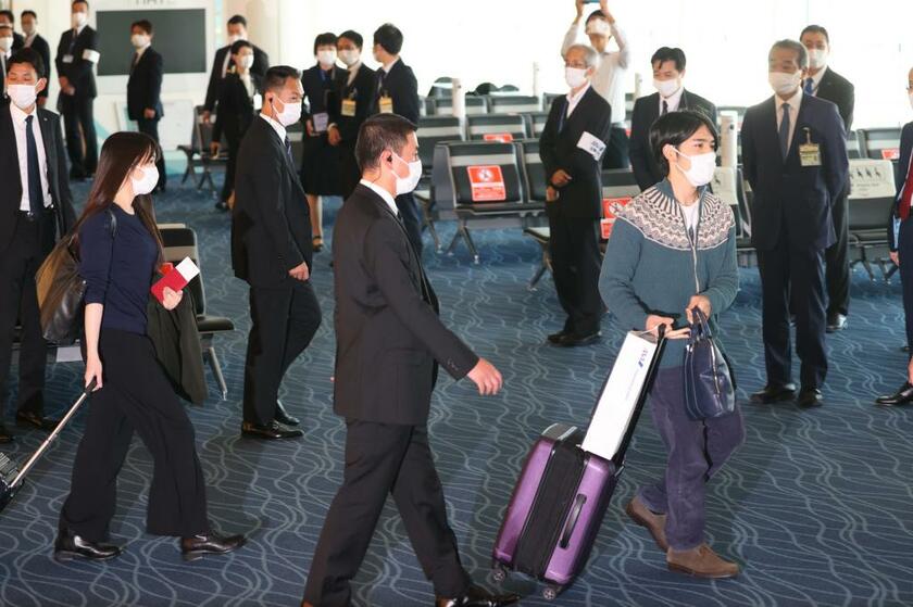 空港内の通路を無言で通り過ぎる小室夫妻（写真部・松永卓也）