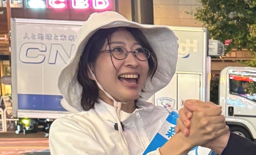街頭で支持者と握手する佐藤氏