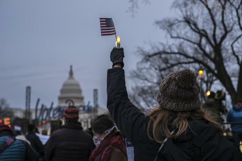 米議事堂襲撃から1年を迎え、キャンドルと米国旗を掲げる人びと／1月6日、ワシントン（photo　gettyimages）