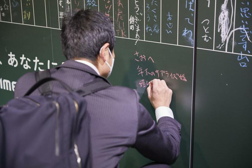 年末年始に池袋駅に設置された伝言板と書き込む人