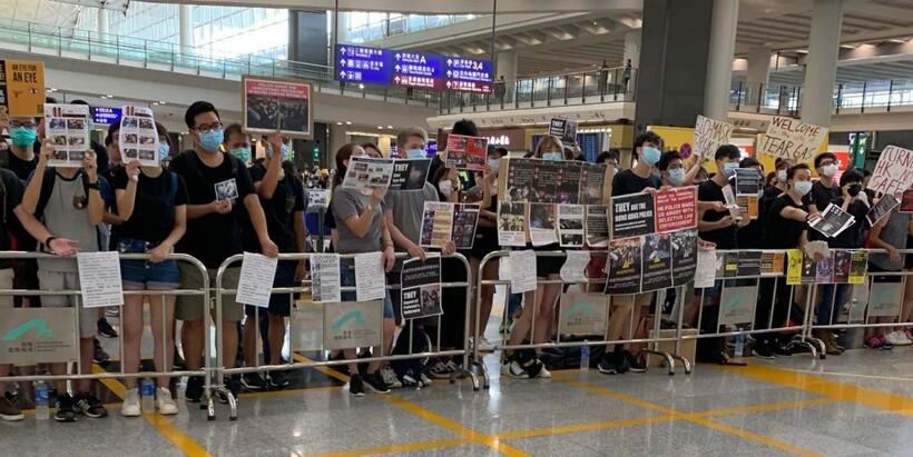 香港国際空港でプラカードを掲げて抗議活動をする人たち＝8月13日