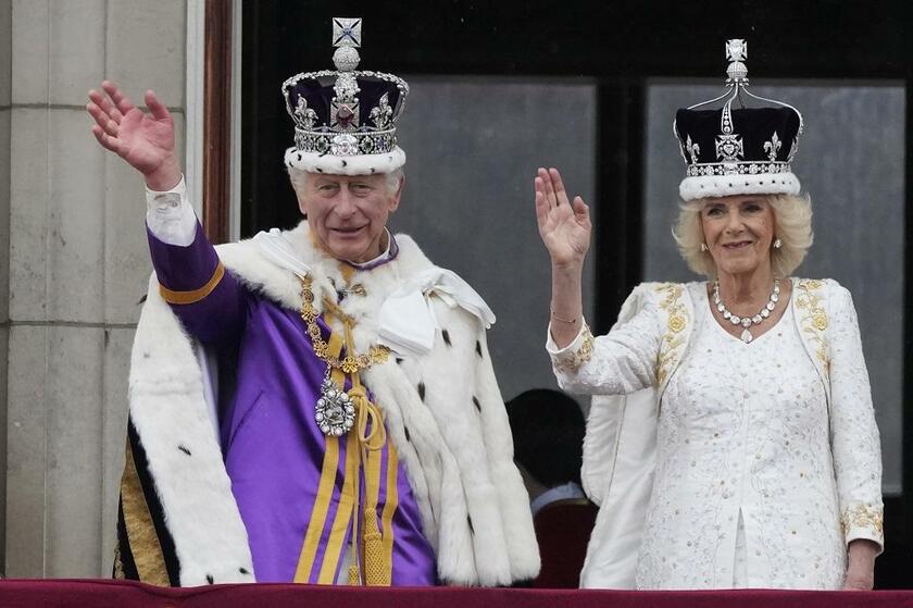 戴冠式後、バッキンガム宮殿のバルコニーから国民に手を振るチャールズ国王とカミラ王妃（写真：AP／アフロ）
