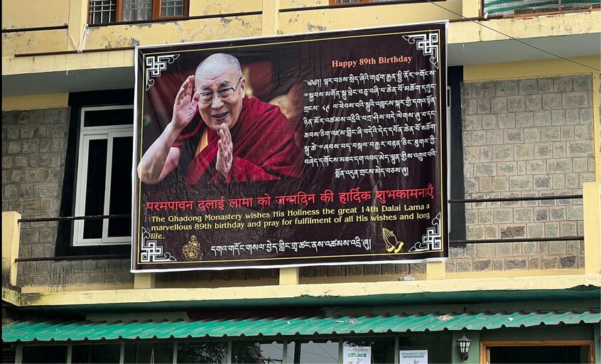 カフェの上に設置された看板は、ダライ・ラマ14世の89歳の誕生日を祝うもの。空港からダラムサラに向かう途中で=2024年9月17日、金牧功大さん撮影