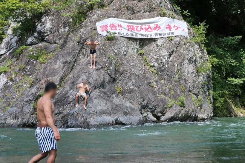 岩の上から川に飛び込む人。東京都青梅市の多摩川で＝米倉昭仁撮影