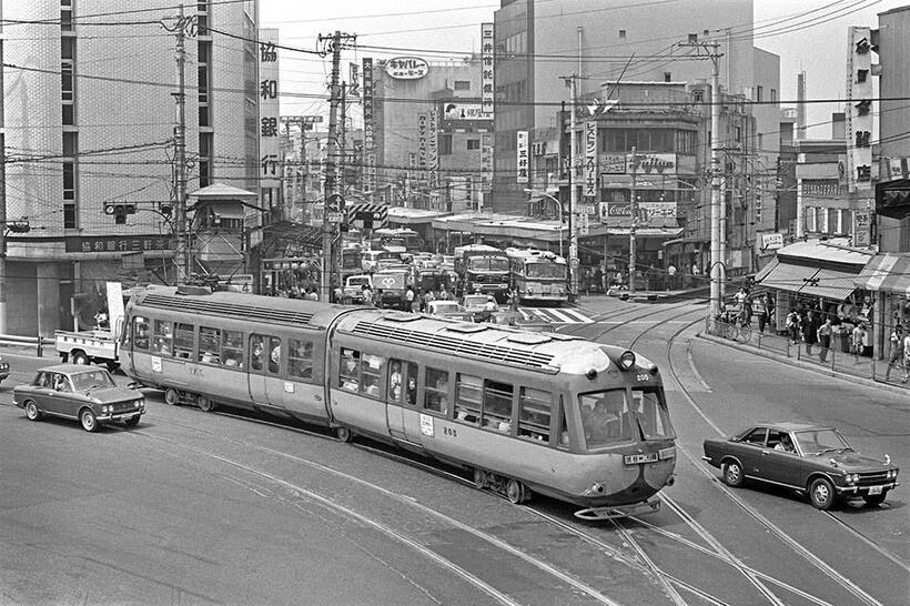 三軒茶屋を発車して、世田谷線との分岐点に差し掛かる玉電近代化のエースデハ200型。玉電の右側を走るのは日産ブルーバード510クーペで、後部を併走するのが日産ブルーバード410と「ブルーバード」の全盛期でもあった。三軒茶屋～三宿（撮影／諸河久：1969年5月10日）