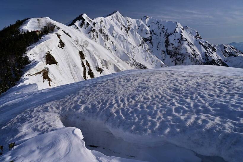 「冷乗越付近の雪庇と鹿島槍」。冷乗越付近は風の通り道で、信州側に大きな雪庇が発達する場所として知られている。残雪期には雪庇の自重で溝ができるが、この溝にはまると時に腰あたりまで潜って出るのに苦労させられる■ニコンZ 7・ニッコール Z 24-70mm f/4 S・ISO200・絞りf13・200分の1秒