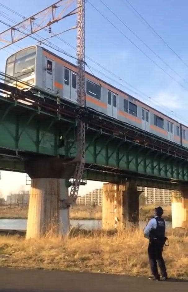 撮り鉄の線路内立ち入りで、多摩川橋梁上に急停車した２０９系中央特快。乗客もいて、警官が出動するなど現場は騒然となった（写真：＠Ｎａｒｕｋａｔｓｕ２０１ｎｅｗさん提供）