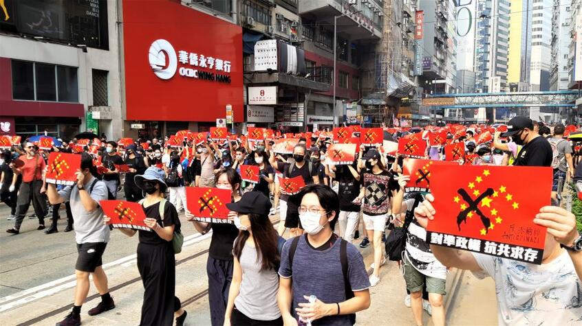 デモ参加者の大半が掲げているプラカードの言葉は「政権に向き合い共産党への抵抗の継続を」。そして「ANTI CHINAZI」(撮影/今井一)