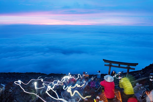 待望の「ご来光」は雲間にわずかに差した程度。それでも、頂上で待ち構えた登山客は、現像的なあかね色の空に魅了されていた／７月１日（撮影／写真部・関口達朗）