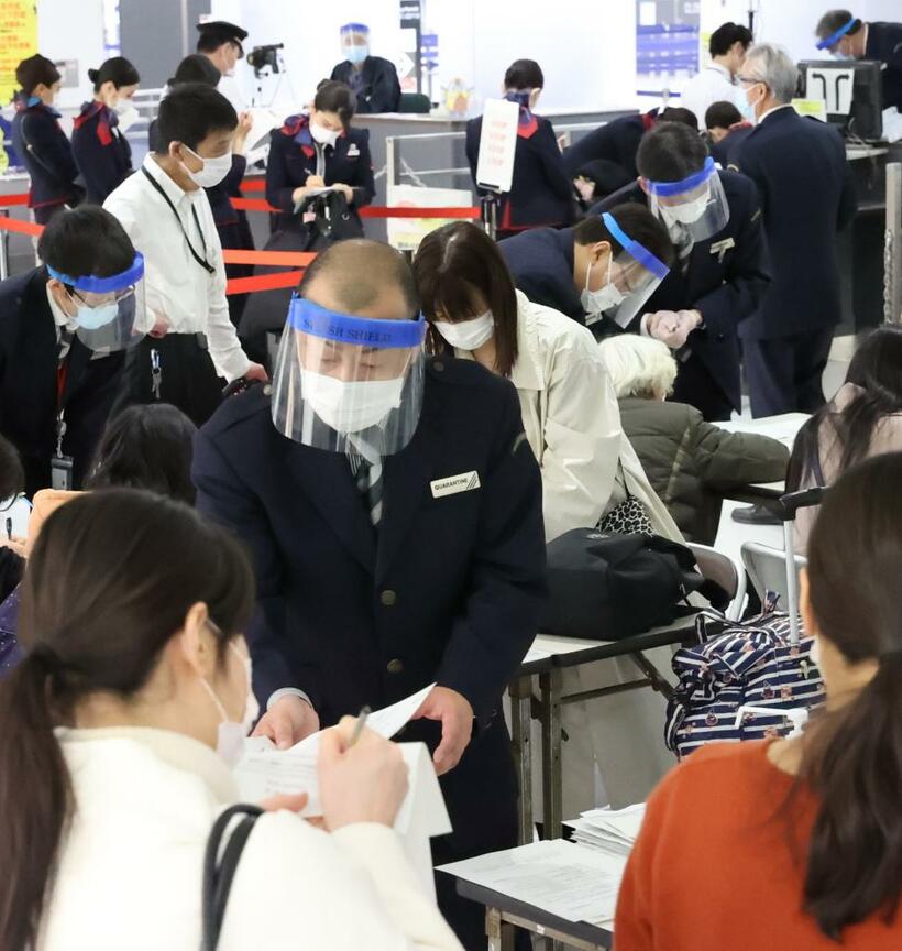 五輪が開催されれば、訪日する関係者の増加も見込まれる。昨年3月、成田空港第2ターミナルの検疫検査場で質問票の記入について説明する検疫官ら　（ｃ）朝日新聞社