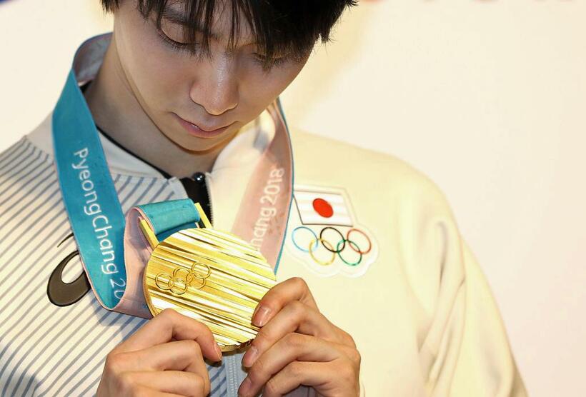 平昌五輪で金メダルを見つめる羽生結弦選手（GettyImages）