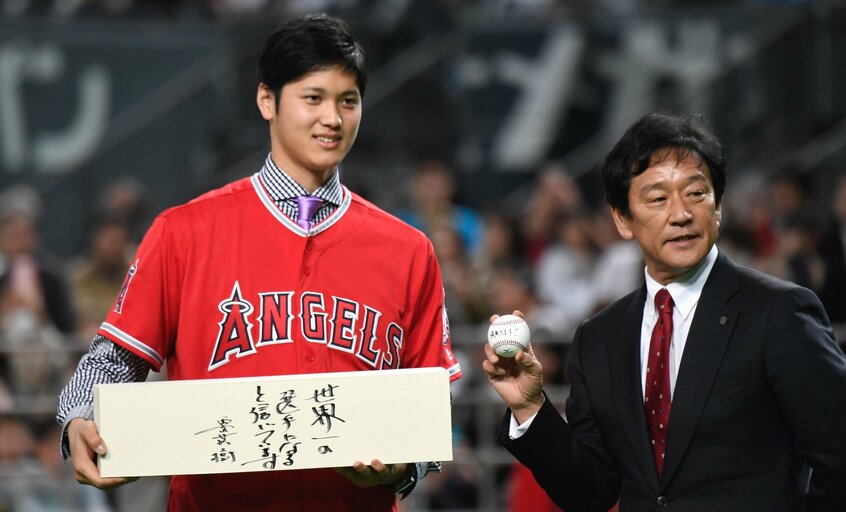 札幌ドームで大勢のファンの前でエンゼルスへの移籍会見をした大谷翔平（左）と日本ハムの栗山英樹監督（当時）