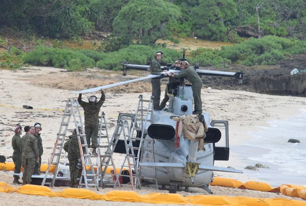 同県うるま市の伊計島に不時着した米軍ヘリから回転翼を外す米軍関係者　（ｃ）朝日新聞社