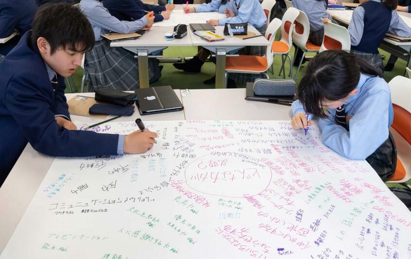 武蔵野大中高/「言語」の授業。考えを紙いっぱいに書いて思考をアウトプットしていく。中高も大学と同じキャンパス内にあり、緑豊かな恵まれた環境で勉学に打ち込める。2018年に就任した日野田校長の「失敗を恐れずチャレンジする精神」が、教員や生徒にも伝わり、学校の雰囲気が変わりつつあるという(写真:学校提供)