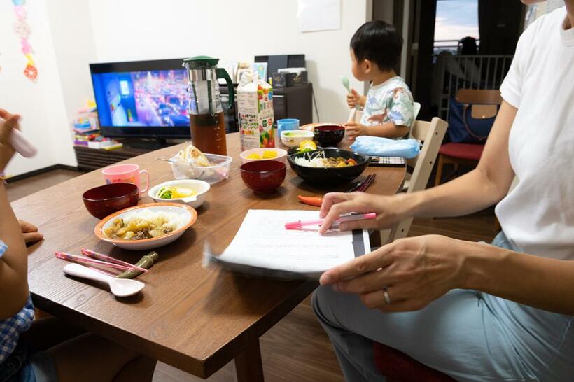 夕飯時にやり残した仕事をこなす。行儀が悪いとわかってはいるが、子どもたちに静かにしておいてほしくてテレビを観せてしまう（ｐｈｏｔｏ　写真映像部・戸嶋日菜乃）