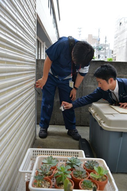 熊本市内の２階建て家屋を実調する熊本支店自動車営業課の遠山淳副長（右）。デジカメで外壁のひび割れを記録する（撮影／写真部・東川哲也）
<br />