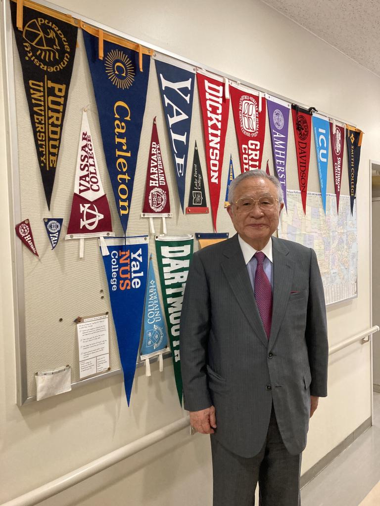 田村哲夫理事長。海外の大学への進学者などからは記念のペナントが贈られた
