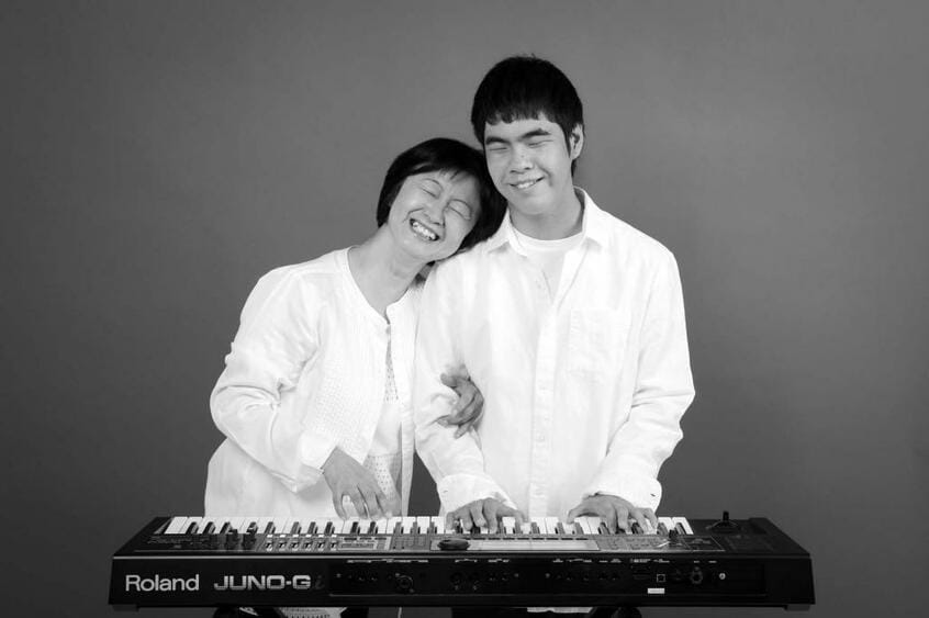 亀井由美子、康生(右、14歳、未熟児網膜症)
<br />【夢】シンガー・ソングライター(康生)
<br />【障害がわかったときの気持ち】不安な気持ちでいっぱいでした。どうか、視力が残りますようにと願い、いろいろな治療や手術を行いましたが、現状は光覚を残すのが精いっぱいでした。初めは悲しみに打ちひしがれましたが「親として、できることは何か?」と思い悩みました。これからの医学の進歩に望みをかけています
<br />【いまの気持ち】夢に向かって頑張ってほしい
<br />(撮影:葛谷舞子)