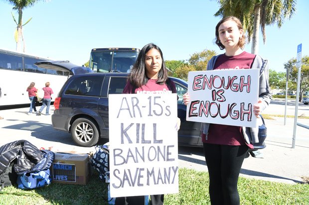 「もうたくさんだ」と書いたプラカードを掲げ（右）、ＡＲ１５（半自動ライフル銃）の禁止を訴えるフロリダ州のマージョリー・ストーンマン・ダグラス高校の元生徒たち　（ｃ）朝日新聞社
<br />