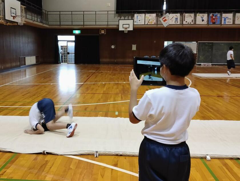 奈良市では全国に先駆けて１人１台が実現した。体育の授業では早速、マット運動を動画で撮影。友だち同士で改善点などをチェックしていた（写真／奈良市教育委員会提供）