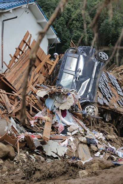 今回の土砂災害で濁流にのまれて全壊した住宅と車（撮影／写真部・松永卓也）