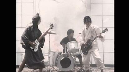 人間椅子のファーストアルバム「人間失格」(1990年)に収録された代表曲「りんごの泪」ミュージックビデオより。鈴木研一(左、ベース)、上館徳芳(中、ドラムス=当時)、和嶋慎治(右、ギター)