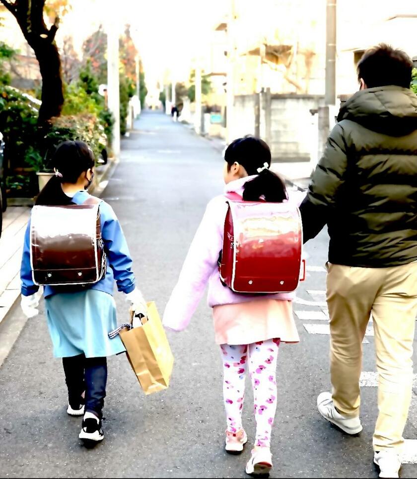 女性(38)の夫(41)と手をつないで通学する小学校2年の娘(8、写真中央)。女性は精神的につらかった時、「一緒にいる時間が増えてラッキー」という気持ちでやってきた(写真:本人提供)
