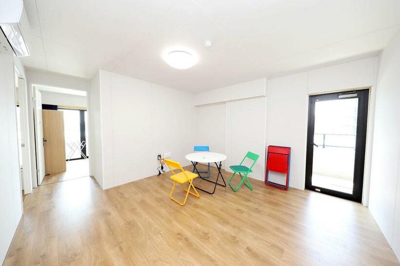 マンションの1室が数部屋に分けられ、共用スペースには白いテーブルと五輪カラーの椅子が置かれている（写真：大会組織委員会提供）
