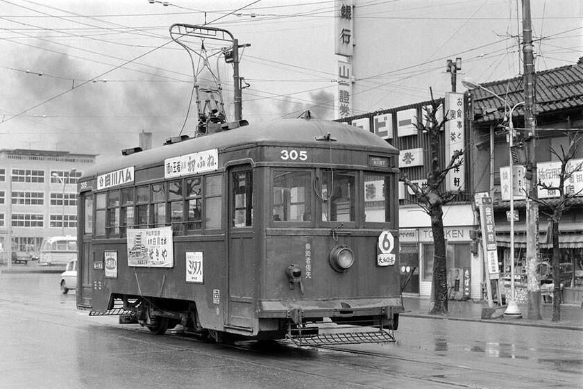 金沢市内線のお目当ては「青電車」だった。1932年・藤永田造船製の高床式四輪単車で、救助網を取り付けた古風なスタイルをしていた。ループ式だった金沢駅前の一コマで、写真の6系統は金沢駅前から兼六園下を結んでいた。（撮影／諸河久）