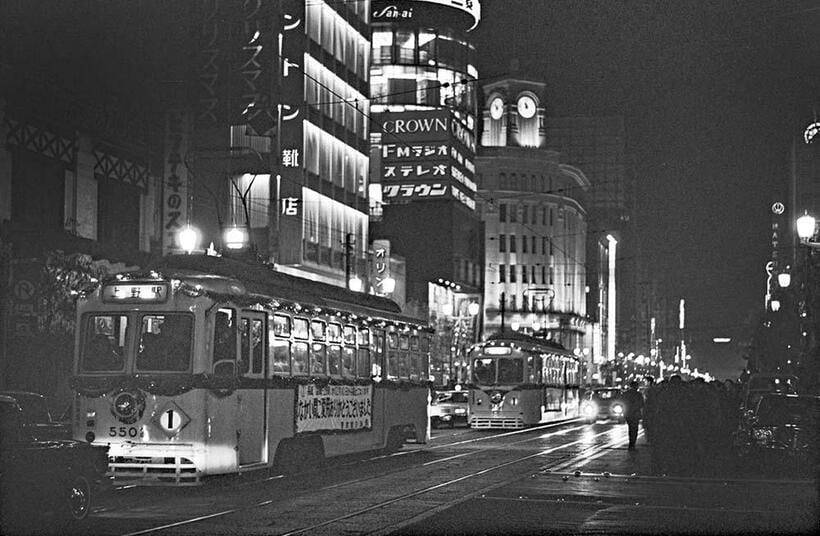 銀座を代表するランドマークを背景に1系統装飾電車の車列が銀座四丁目交差点に向ってゆっくり走り始めた。和光本館の大時計は午後10時55分をさしている。銀座七丁目～銀座四丁目（撮影／諸河久：1967年12月9日）