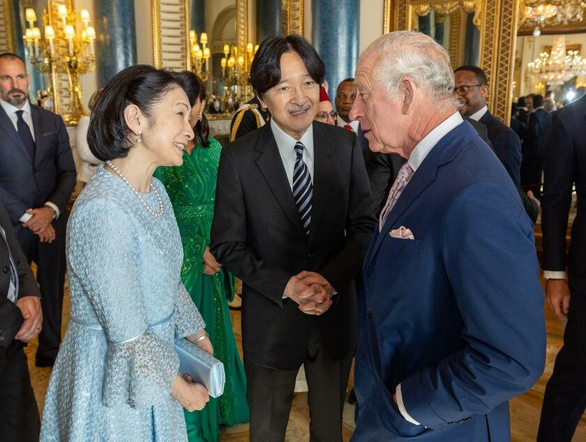 戴冠式前日の５月５日、レセプションでチャールズ新国王と談笑する秋篠宮ご夫妻。紀子さまは淡いロイヤルブルーのドレス姿だった（写真：KCS／アフロ）