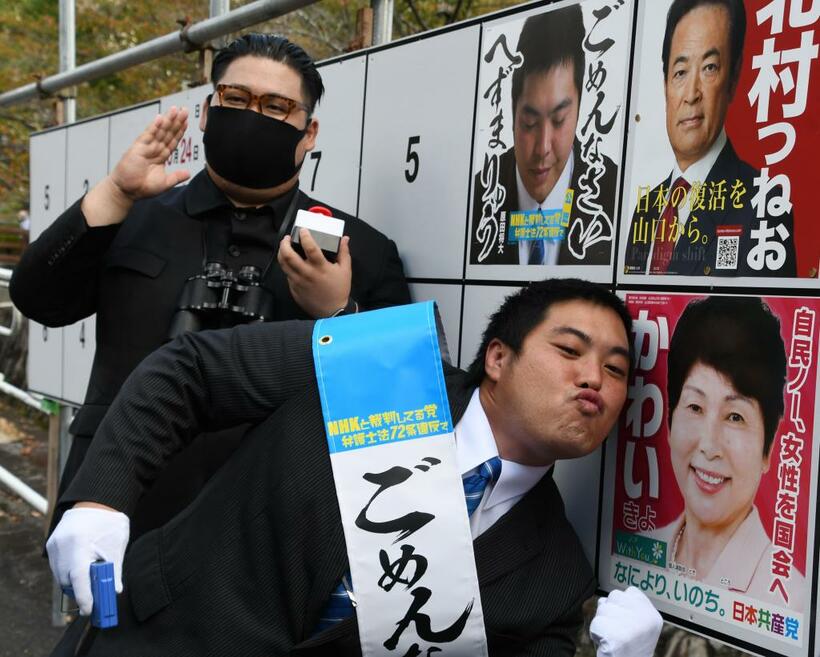 選挙ポスターの前で金正恩のそっくりさんとポーズをとるへずまりゅう（C)朝日新聞社